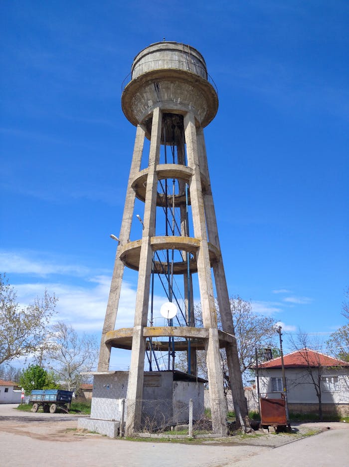 A tall concrete water tower stands prominently against a clear blue sky in Türkiye.